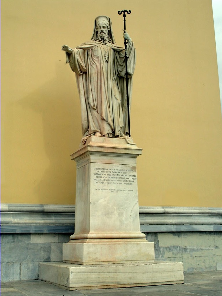 Ανδριάντας Πατριάρχου Γρηγορίου Ε΄ στο δεξιό μέρος της πρόσοψης του Πανεπιστημίου Αθηνών.